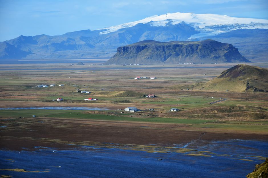Captivating landscape of Icelandic mountains and villages with clear skies.