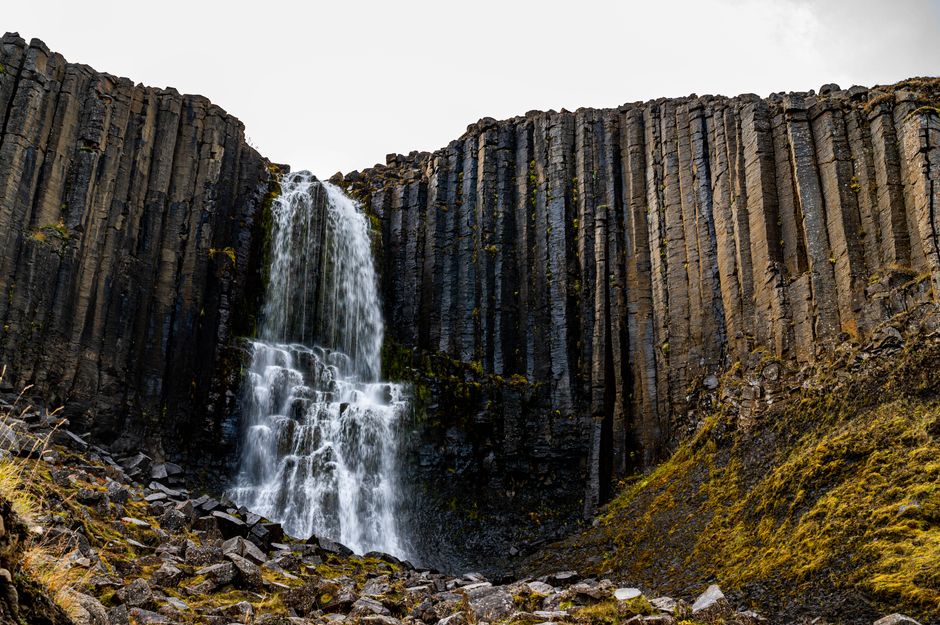 Majestic waterfall cascading over unique basalt columns, showcasing Iceland's natural beauty.