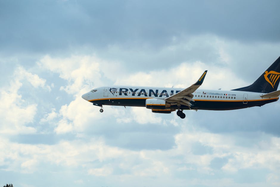 Ryanair airplane in mid-air cruising against a vibrant cloudy sky.