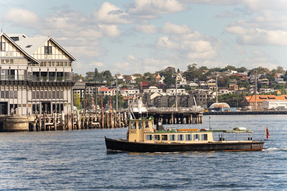 A charming view of a ferry passing by Barangaroo in Sydney Harbor, capturing the essence of urban waterfront life.