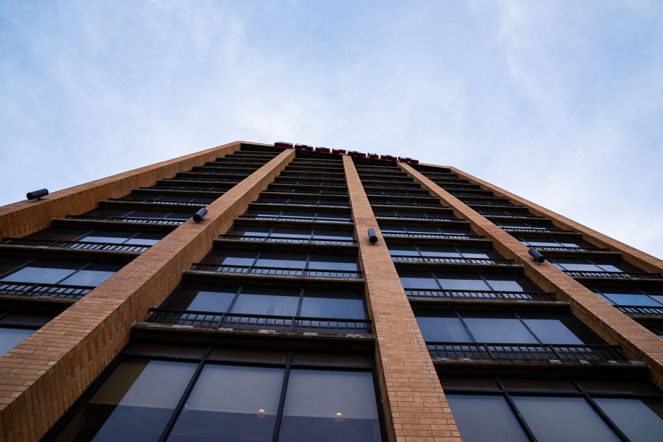 Perspective view of a tall brick building reaching into the clear blue sky, capturing the modern architecture.