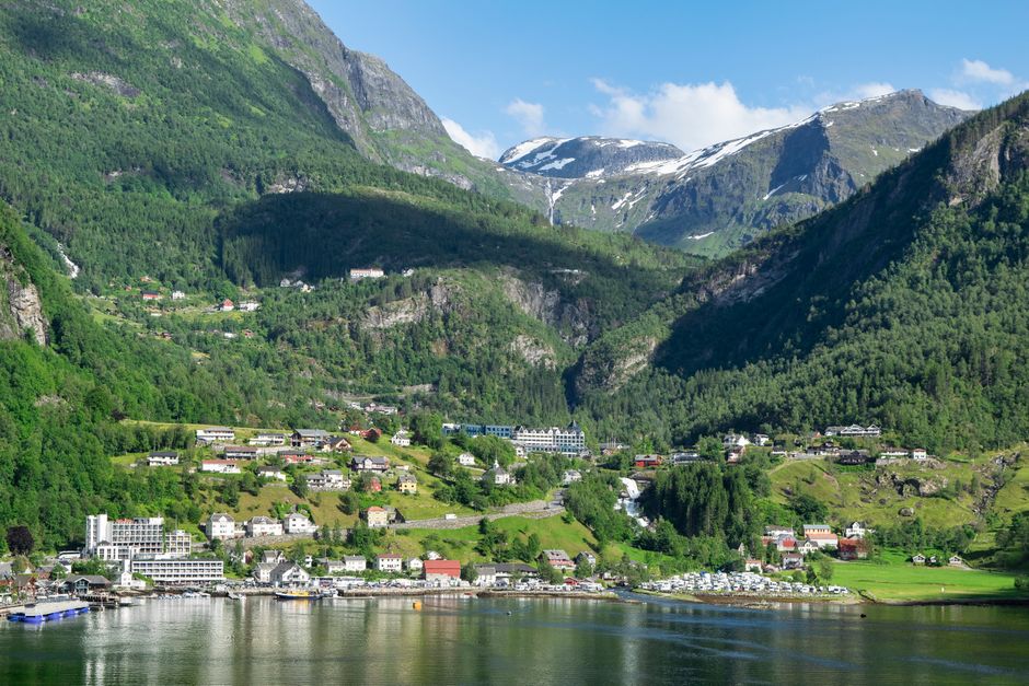 Charming town nestled in lush, green mountains by a serene lake.