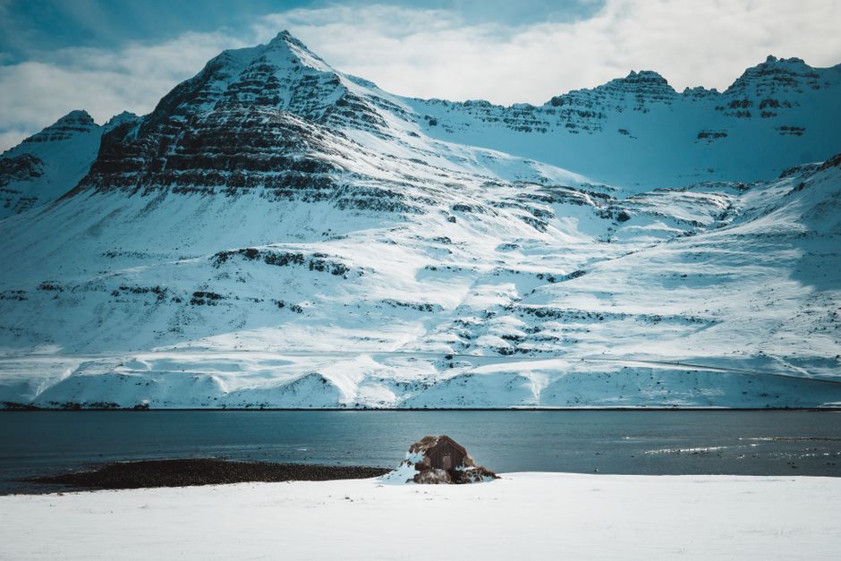 Breathtaking view of snow-covered mountains and a calm lake, exuding serenity and winter's beauty.