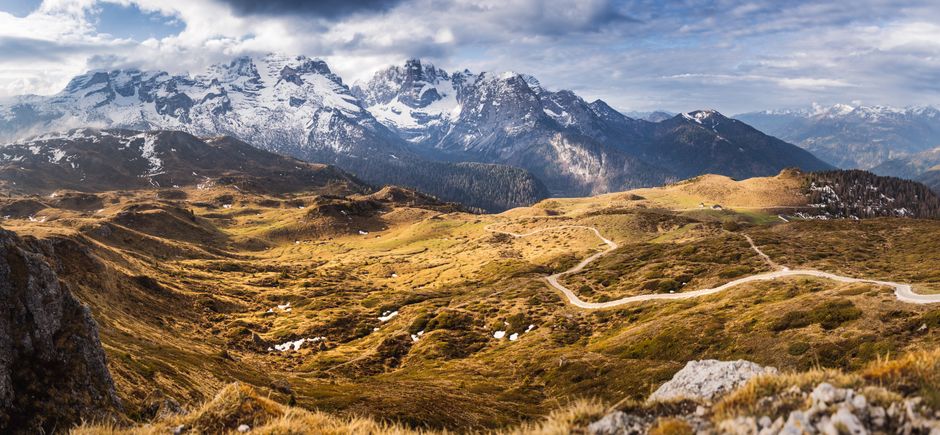 Breathtaking view of snow-capped mountains and winding paths in the Alps.