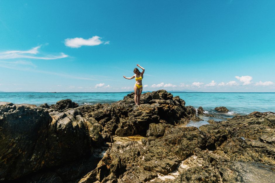 Woman enjoying summer on rocky coastline in Ao Nang, Thailand.