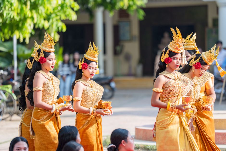 Women in traditional Khmer attire performing Apsara dance outdoors in Battambang, Cambodia.