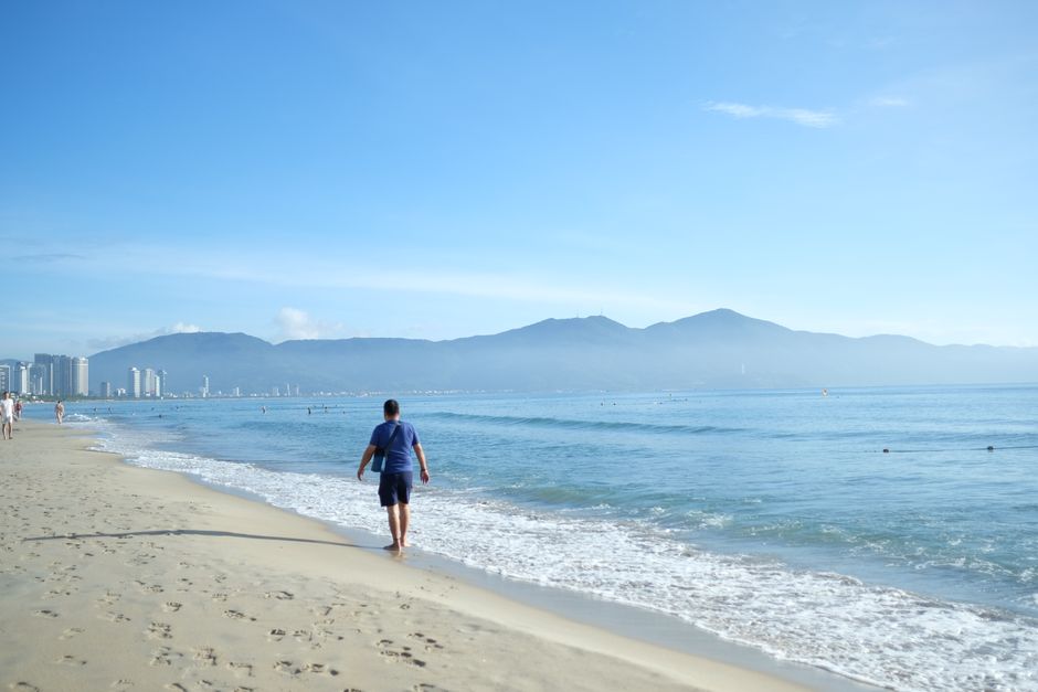 A peaceful morning stroll along Da Nang beach with stunning mountain views.
