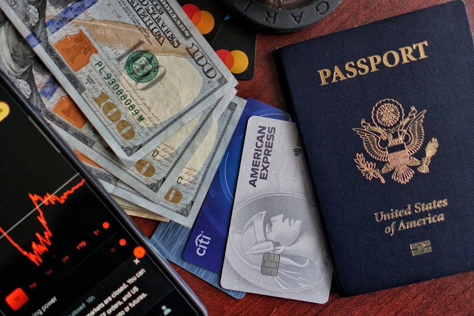 United States passport, cash, credit cards, and smartphone displaying stock market chart.