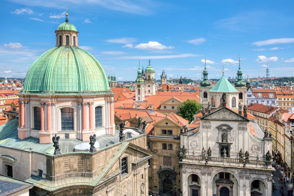 Explore the stunning aerial view of Prague's historic skyline featuring iconic churches and architecture.