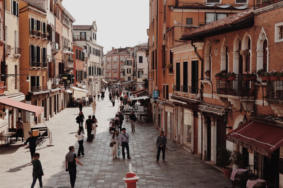Explore a bustling Venetian street showcasing historic architecture and vibrant urban life.