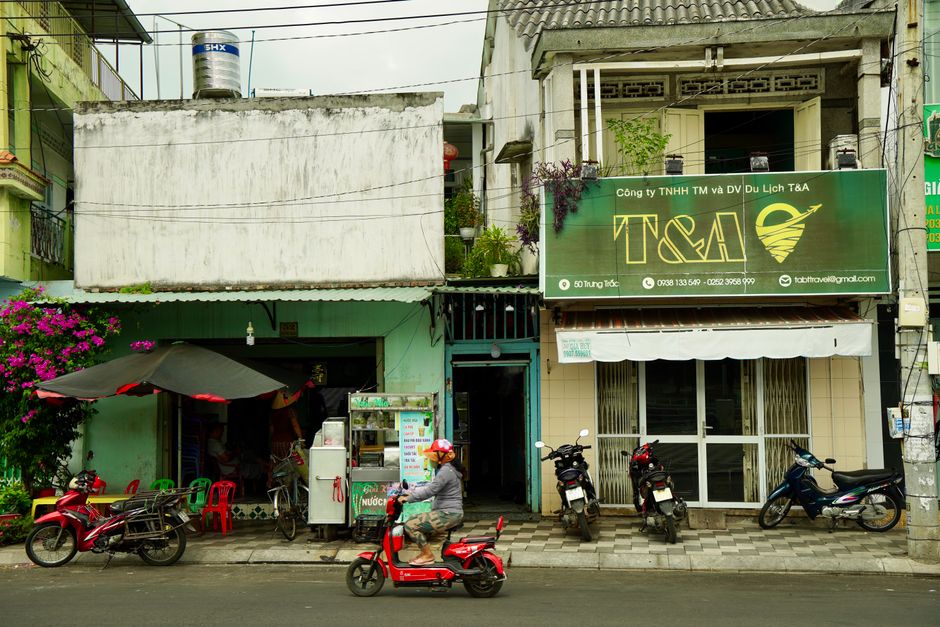 Busy Vietnamese street with shops, motorbikes, and vibrant colors.