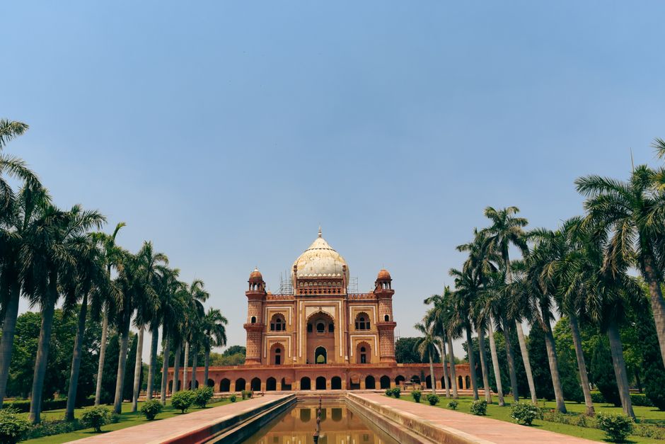 A view of Safdarjung Tomb surrounded by palm trees in Delhi, India.