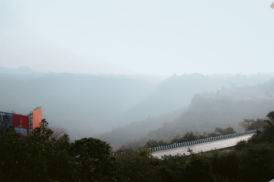 Peaceful mountain road enveloped in fog, offering a tranquil and atmospheric landscape view.