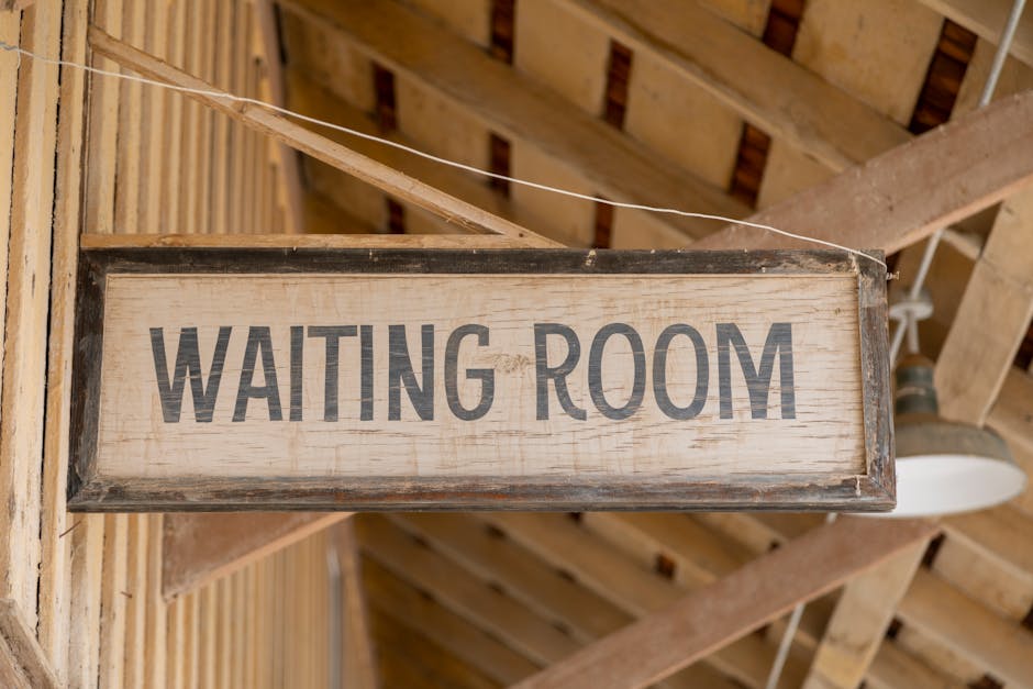 Close-up of a vintage wooden 'Waiting Room' sign in rustic surroundings.